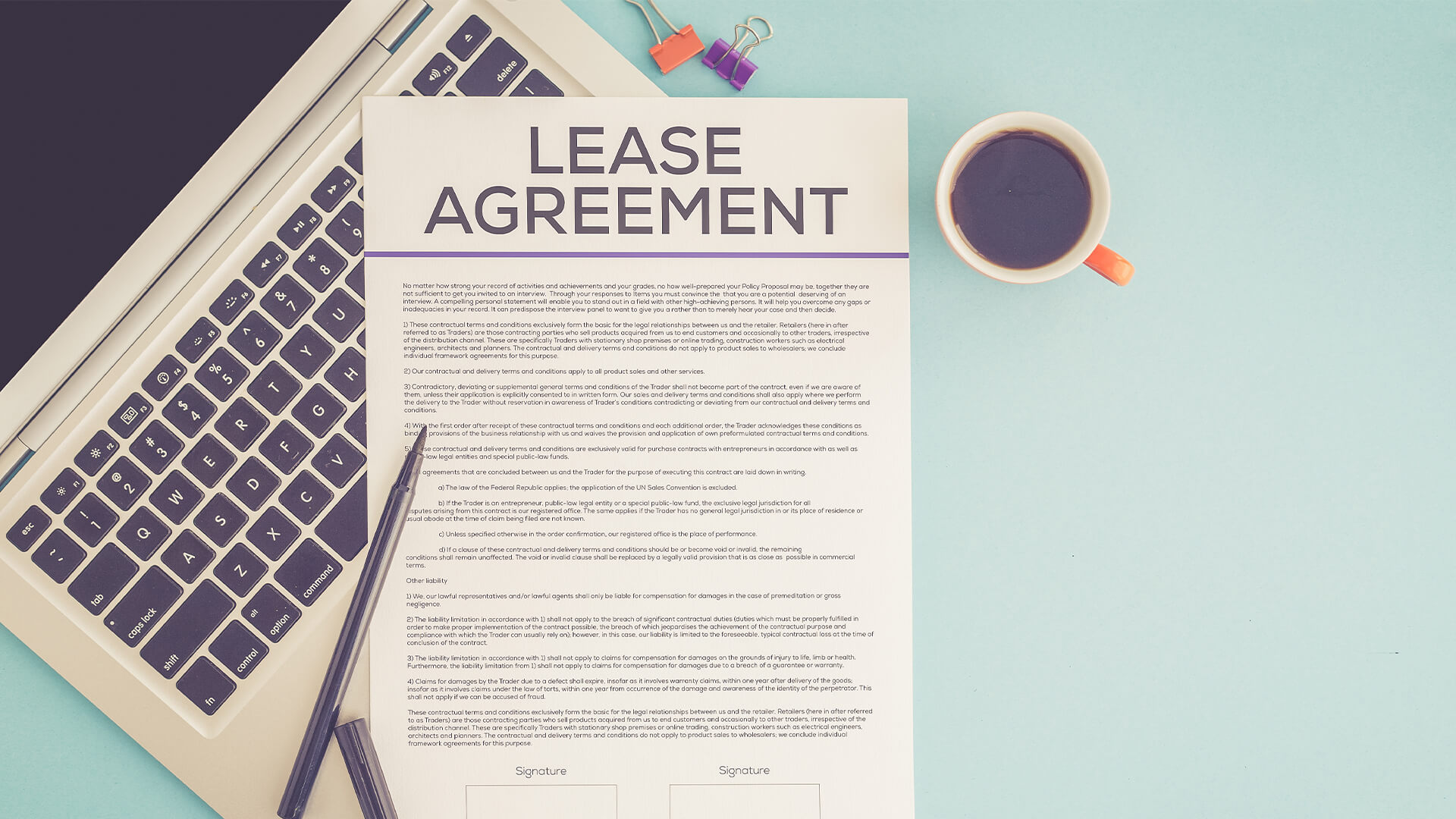 A lease agreement document next to a laptop and a cup of coffee against a blue background