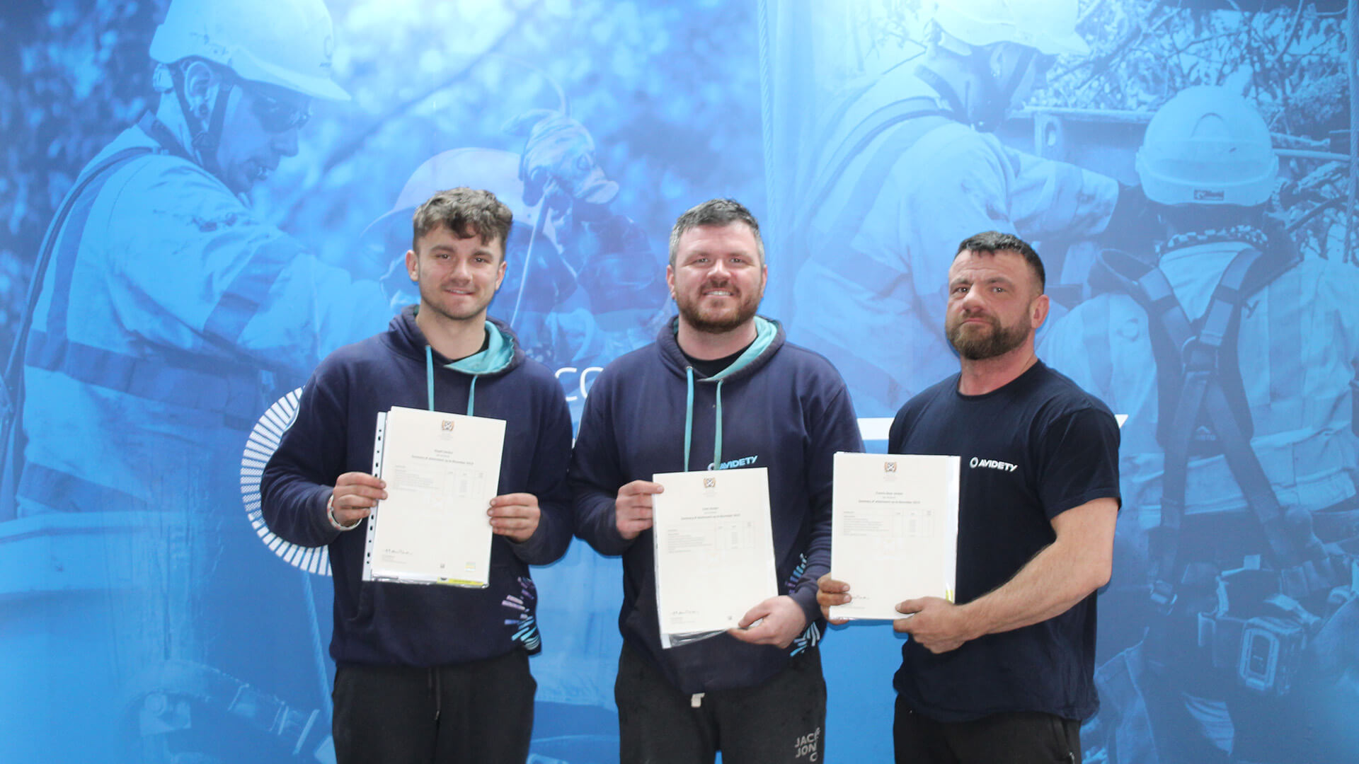 3 Men Standing, Each Holding a Certificate